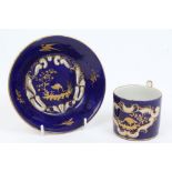 Early 19th century French porcelain cup and saucer with raised gilt bird and scroll decoration on a