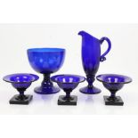 Three early 19th century Bristol blue glass urn-shaped salts, raised on square socles, 6.
