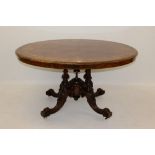 Victorian inlaid walnut oval loo table with finely figured and floral scroll inlaid top on carved