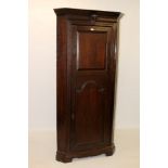 18th century oak two height corner cabinet with cherub head corbel to shaped pediment,