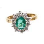 Emerald and diamond cluster ring, the oval mixed cut emerald measuring approximately 8.03mm x 6.