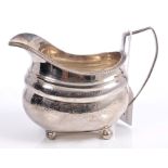 George III silver cream jug of bellied form, with bright cut decoration and gadrooned rim,