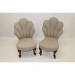 Pair of Victorian walnut fan back nursing chairs with pale beige upholstery on carved scrolled