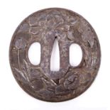 19th century Japanese steel tsuba of circular form, decorated in relief with chrysanthemums, signed,