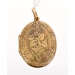 Victorian engraved yellow metal oval locket with engraved foliate decoration to each side,