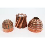 Three antique copper jelly moulds - the largest 11cm high