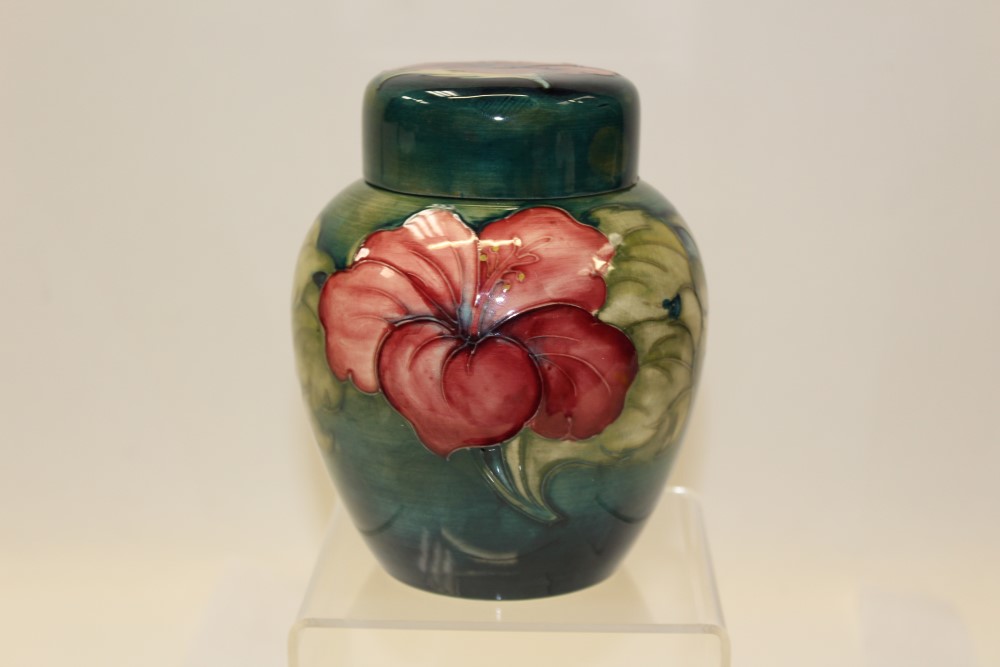 Moorcroft pottery ginger jar and cover decorated in the Hibiscus pattern on blue and green ground -