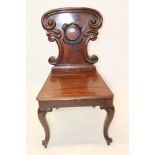 Early Victorian mahogany hall chair with shield shaped back and solid seat on cabriole legs