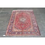 Kashan rug with allover scrolling floral ornament on red ground in multiple borders,