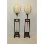 Pair of Chinese carved hardwood standing lamps, raised on H-form base,