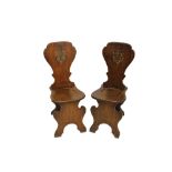 Good pair of mid-18th century oak and armorial painted hall chairs, each wide solid shaped back,