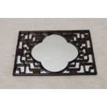 Chinese hardwood mirror of rectangular form with raised meandering lattice overlay,