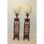 Pair of Chinese carved and pierced standard lamps with pierced tablet frieze raised on multiple