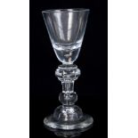 Early 18th century wine glass with funnel bowl and solid base with tear on annular knopped hollow