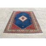 Large Eastern rug with midnight blue ground centred by a cream lozenge in multiple geometric