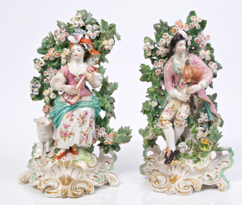 Pair of 18th century Derby figures of musicians with lamb and floral bocage,