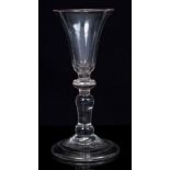 Georgian gin glass with bell-shaped bowl over knop and inverted knop below, on domed folded foot,