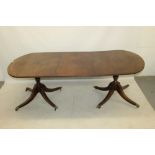 Mahogany twin pedestal dining table, the rounded rectangular top with reeded edge,
