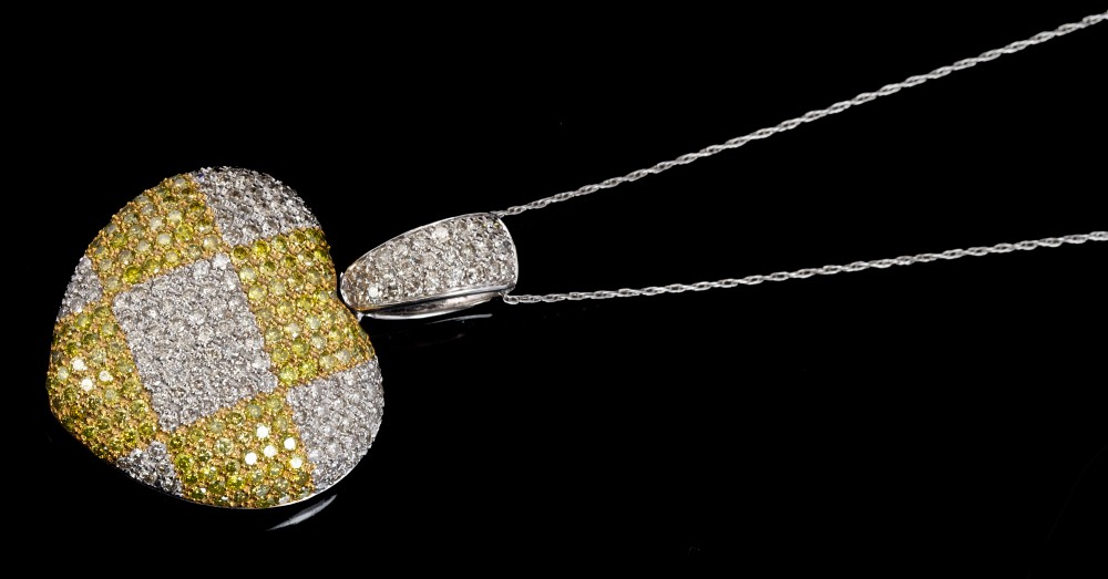 White and yellow metal diamond heart-shape pendant of bombe form, with chequered design,