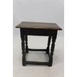 Oak joint stool with moulded top on scroll carved frieze and turned supports united by stretchers,