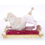 Early 19th century Minton model of a poodle in playful pose, on puce and gilt cushion base, 12cm,