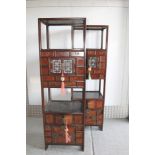 Pair of Chinese hardwood standing cabinets, having two open shelves with panelled cupboards below,