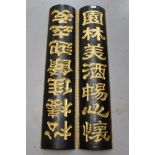 Pair of Chinese black and gilt carved panels of bowed form, with calligraphic script,