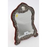 Edwardian silver dressing table mirror of waisted form, with rococo scroll and foliate decoration,