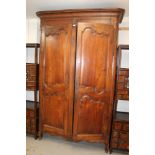 Very large 19th century French fruitwood armoire with concave cornice and enclosed by a pair of
