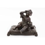 Late 19th century bronze figure of a seated child with a drum, having a tantrum, on pillow base,