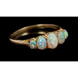 Opal five stone ring with five graduated opal cabochons in carved gold setting, on tapered shank.
