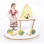 Unusual 19th century Staffordshire porcelain group of a girl with watering can, beside a beehive,