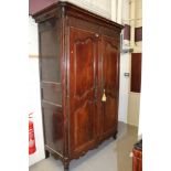 19th century French chestnut armoire with concave cornice and enclosed by a pair of shaped fielded
