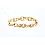 Yellow metal bracelet with stylised bamboo links, with naturalistically textured finsih,
