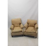A near pair of early 20th century deep upholstered armchairs in the manner of Howard & Sons,