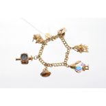 Gold (9ct) charm bracelet with numerous gold and yellow metal novelty charms