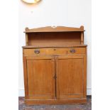 Regency pine chiffonier with shelf gallery and frieze drawer over pair of panelled cupboard doors,