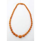 Old amber necklace with graduating polished oval beads and concealed twist clasp,