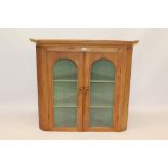 19th century pine standing corner cupboard with three shelves enclosed by arched glazed doors and