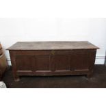 Very substantial oak coffer with plank top and four-panel front raised on stiles,