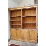 Antique pine bookcase, in two parts with adjustable shelves and two pairs of cupboards below,