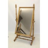 Early 20th century pine cheval mirror, the rectangular plate flanked by turned supports,