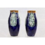 Two Edwardian Royal Doulton vases with green foliage on blue ground, 25.