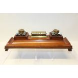 Early 20th century mahogany desk inkstand with two brass mounted cut glass inkwells and a central