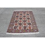 Tribal rug with four rows of seven serrated boteh in multiple geometric borders,