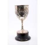 Edwardian silver cup of goblet form, with embossed floral and foliate decoration,