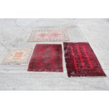 Tekke-style rug with three-quartered medallions against deep red field in geometric borders,