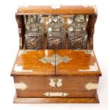 Early 20th century oak and silver plate mounted tantalus housing three cut glass decanters and