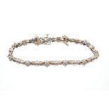 White and yellow gold diamond bracelet with eleven clusters of brilliant cut diamonds interspaced
