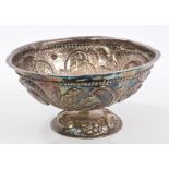 Antique white metal bowl of circular form, with raised panels of floral decoration and flared rim,